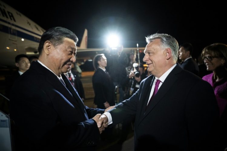 Chinese President Xi Jinping (L) is greeted by Hungarian Prime Minister Viktor Orban (R) at the airport. ©AFP